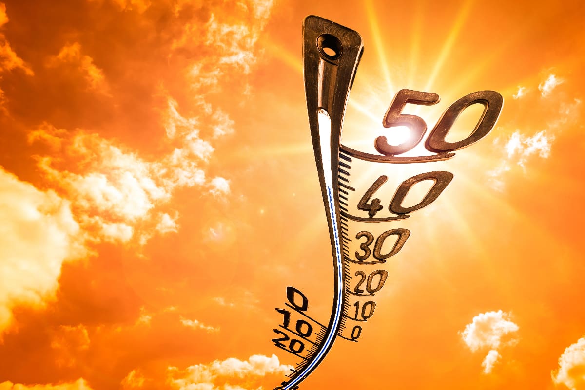 image d'un thermomètre déformé par la chaleur et dans le fond un ciel avec un soleil brillant