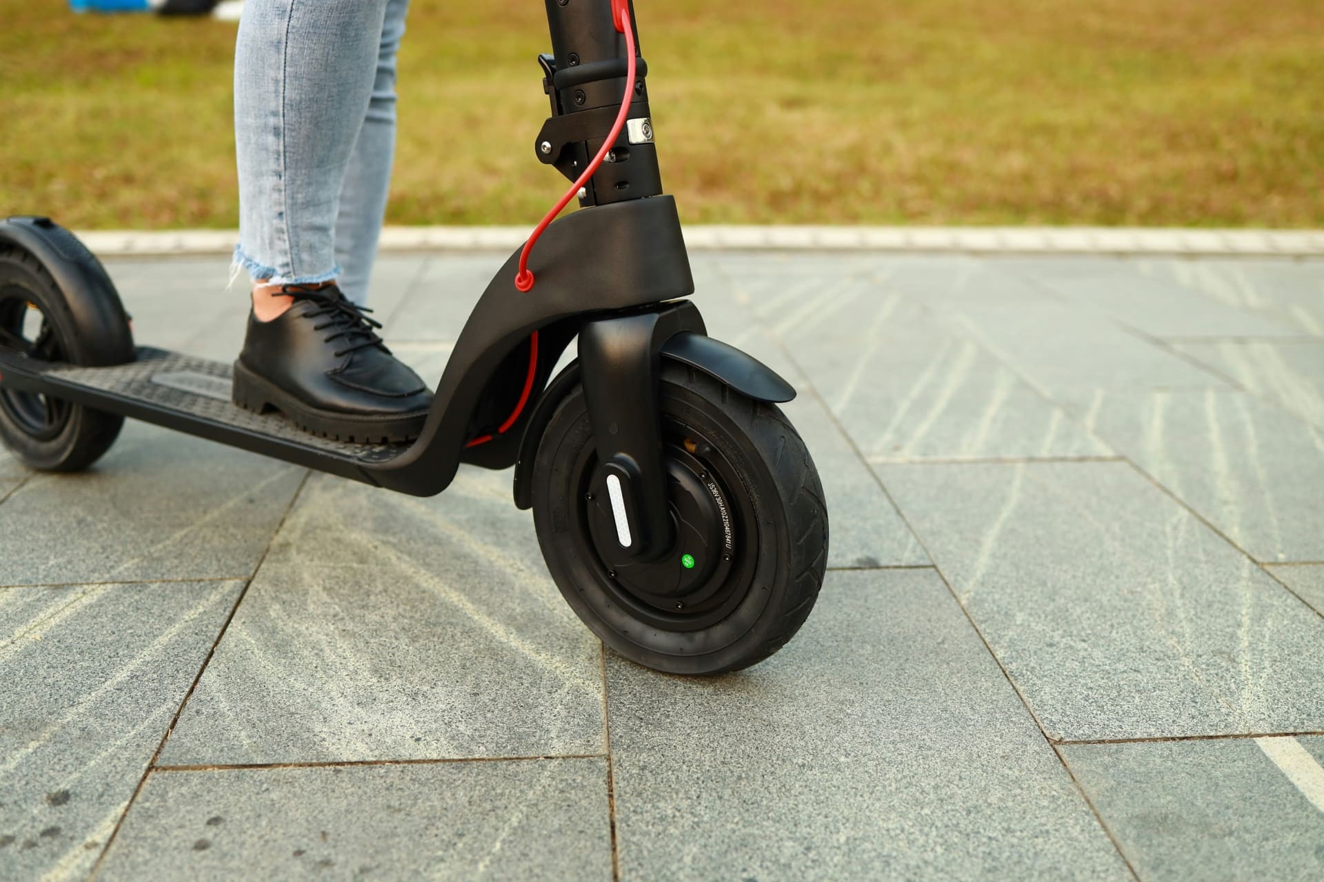 Photo de la jambe d'une personne sur une trottinette électrique
